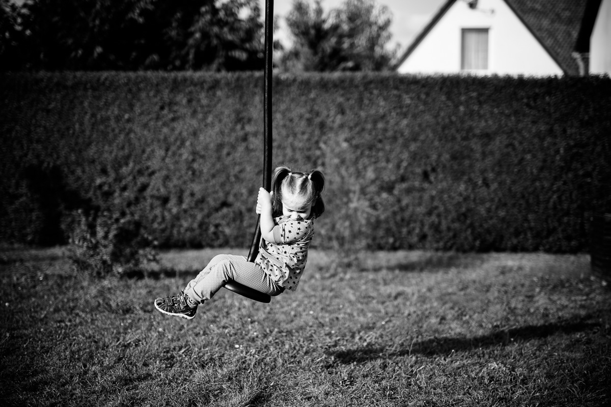 kleines Mädchen hängt an einer Seilbahn
