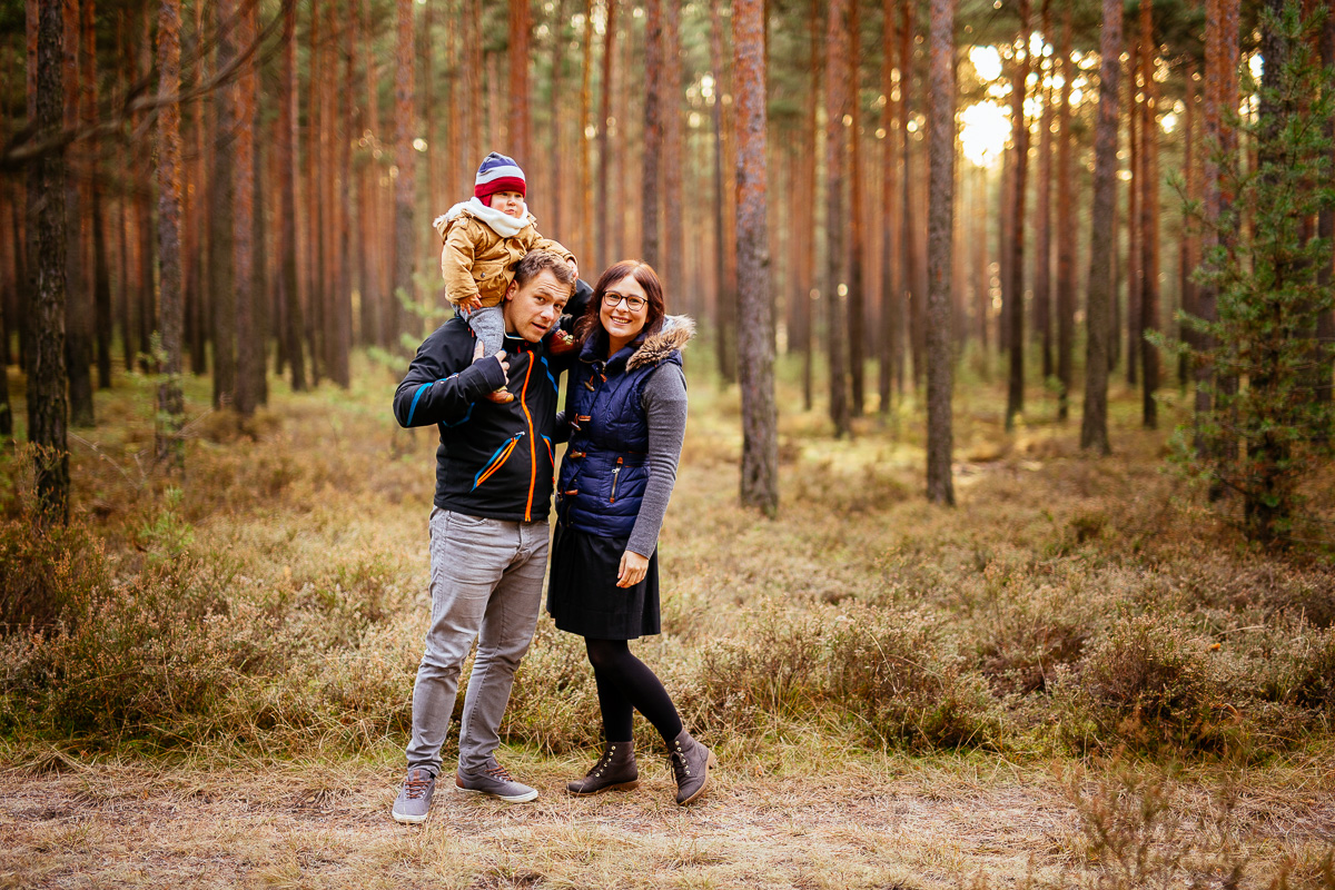 Mutter und Vater mit Sohn posieren im Wald